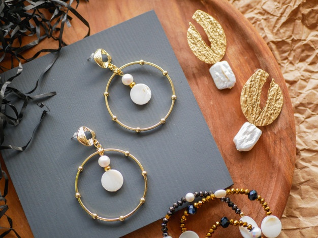 gold-earrings-women-s-jewelry-vintage-decoration-background-beautiful-golden-tones-brooches-bracelets-necklaces-earrings-wooden-tray-flat-lay-top-view_96872-3129